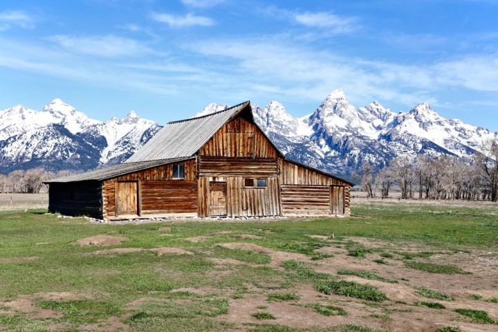 a house covered in snow with a mountain in the background